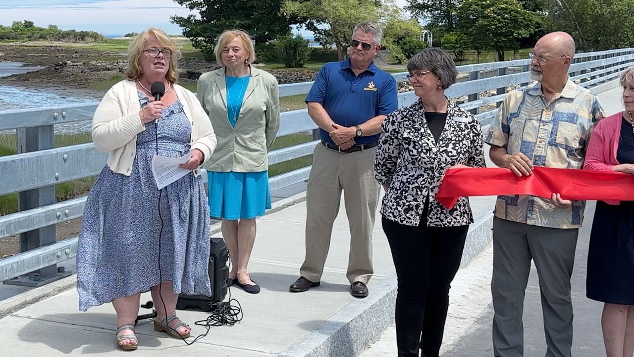 Kennebunkport Town Manager Laurie Smith, left, delivers remarks at the official re-opening of the Pier Road causeway in Kennebunkport Monday. Officials, including Gov. Janet Mills, to Smith's left, look on. (Spectrum News/Sean Murphy)