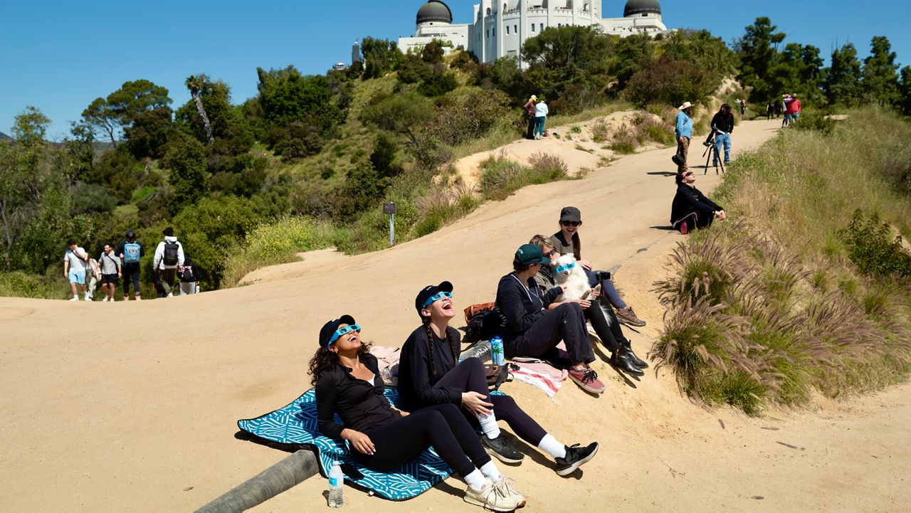 Spectators use special glasses to watch a solar eclipse near Griffith Observatory on Monday in Los Angeles. (AP Photo/Andy Bao)