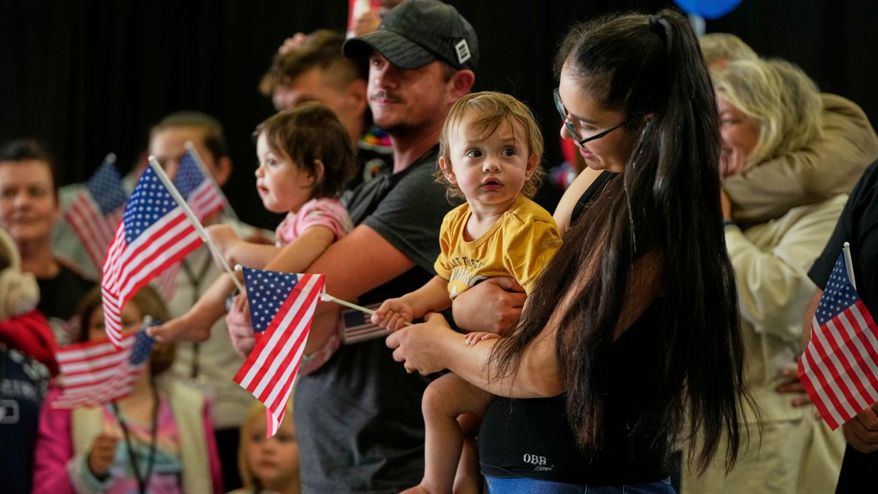 Afrikaner refugees from South Africa holding American flags arrive, Monday, May 12, 2025, at Dulles International Airport in Dulles, Va. (AP Photo/Julia Demaree Nikhinson)