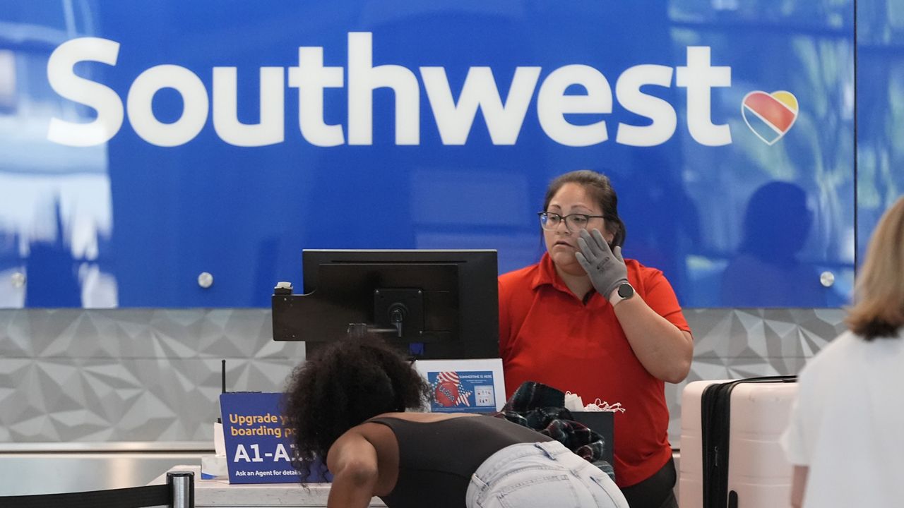 A Southwest Airlines ticket agent checks in passengers at Love Field in Dallas, July 25, 2024. (AP Photo/LM Otero, File)