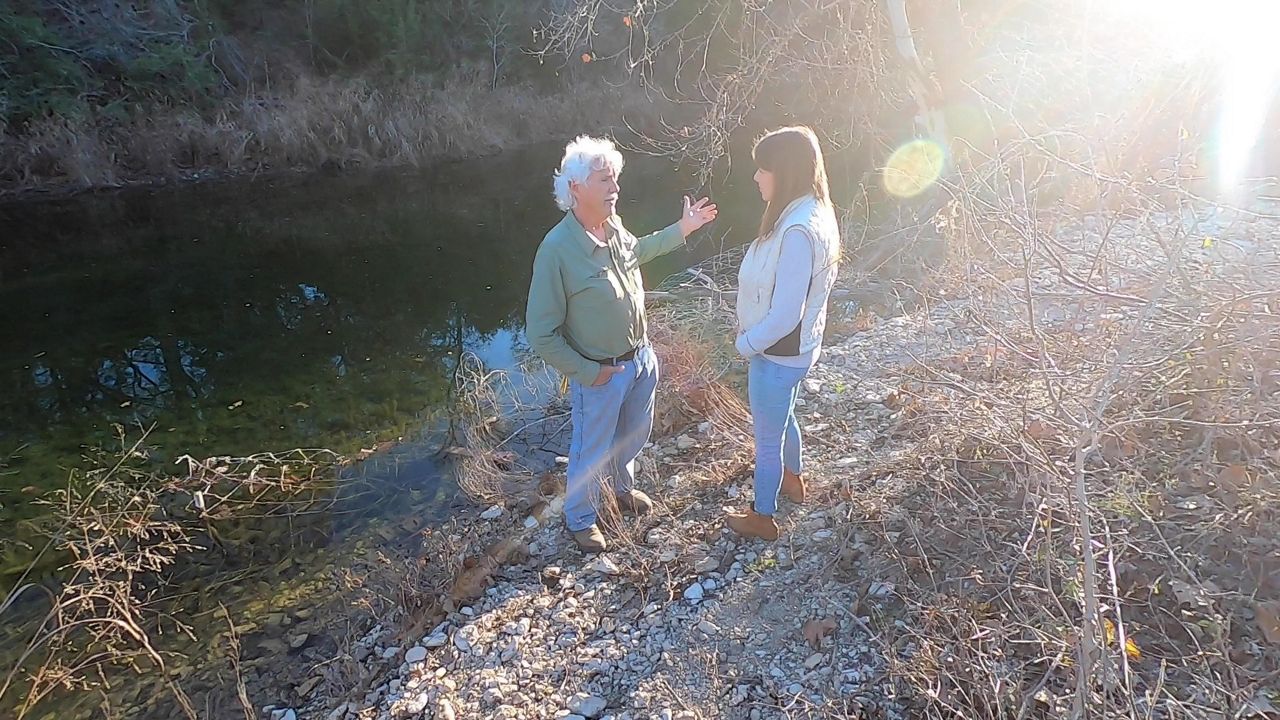 Ira Yates and Katherine Romans talk by a river