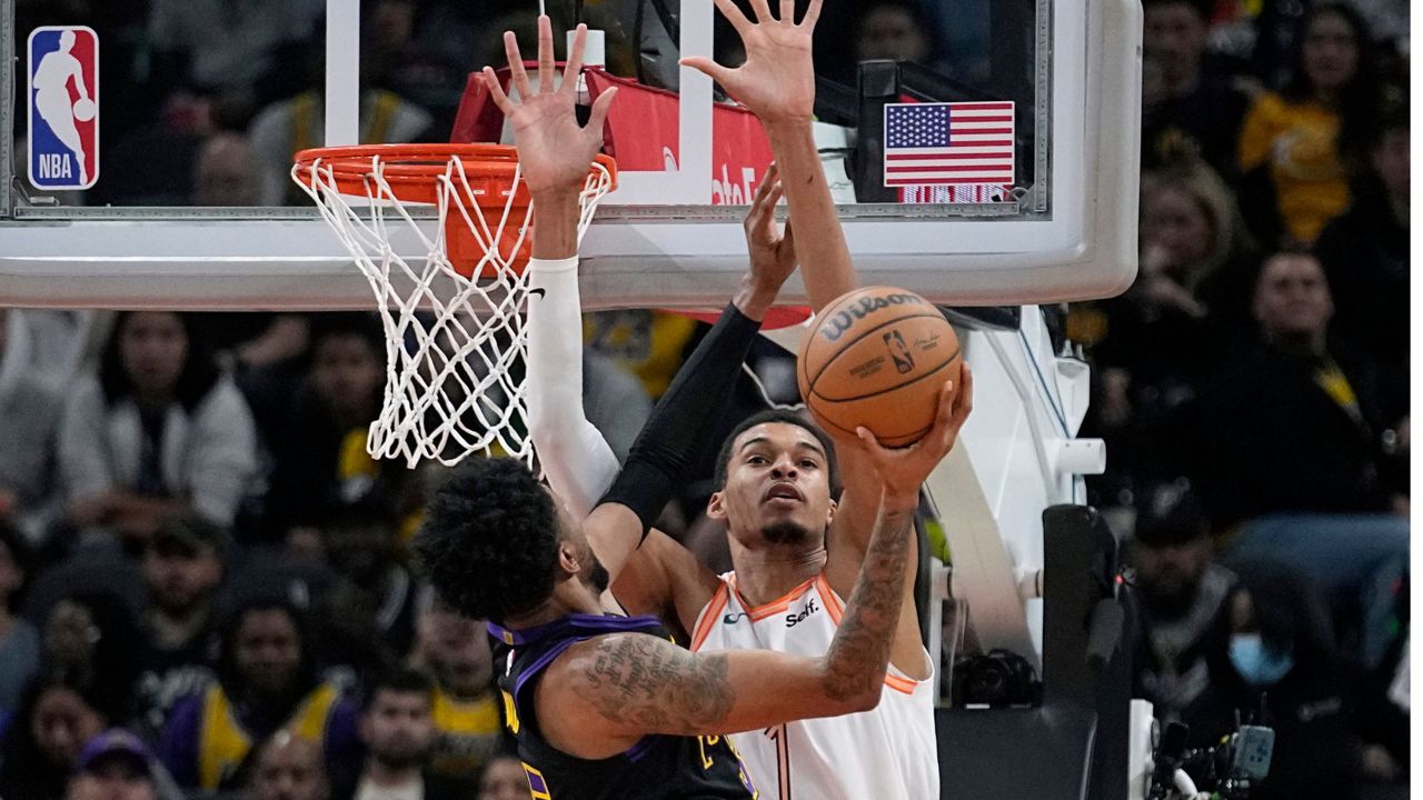 Los Angeles Lakers forward Christian Wood drives to the basket against San Antonio Spurs center Victor Wembanyama (1) during the first half of an NBA basketball game in San Antonio, Friday, Dec. 15, 2023. (AP Photo/Eric Gay)