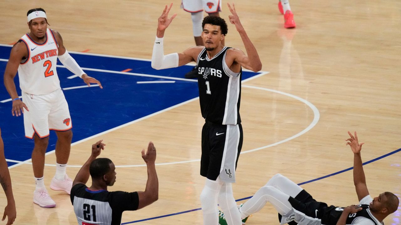 San Antonio Spurs' Victor Wembanyama (1), center, reacts as he sinks a three point basket during the second half of an NBA basketball game against the New York Knicks, Wednesday, Dec. 25, 2024, in New York. (AP Photo/Seth Wenig)