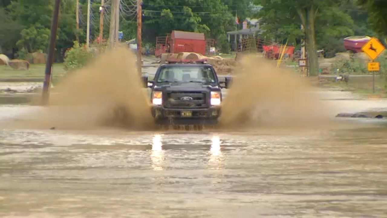 A vehicle drives through a flooded road in Steuben County (Spectrum News 1)