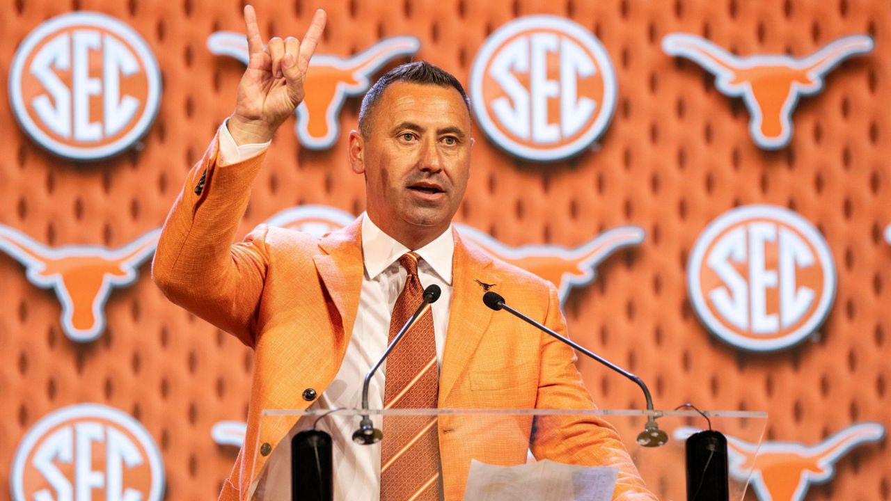 Texas head football coach Steve Sarkisian flashes the "Hook 'Em Horns" sign after speaking at the Southeastern Conference NCAA college football media days Wednesday, July 17, 2024, in Dallas. (AP Photo/Jeffrey McWhorter)