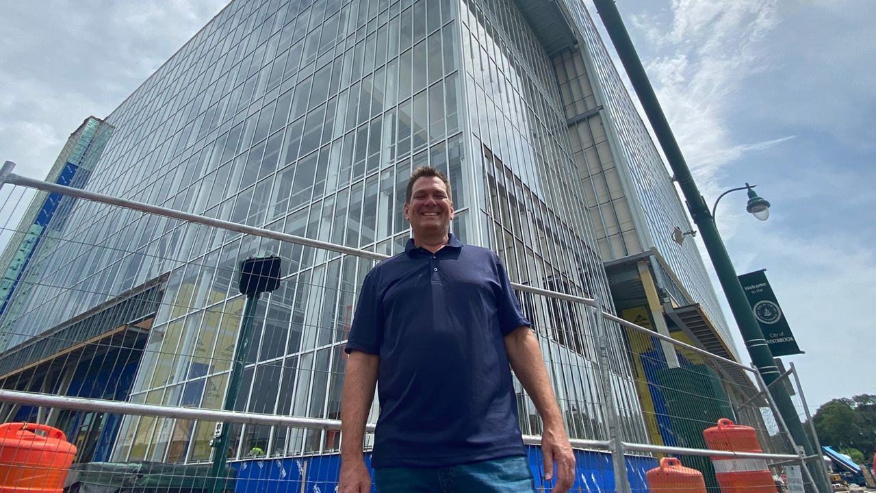 Westbrook Economic Developer Dan Stevenson is banking on the new Vertical Harvest project, seen behind him, and a new parking garage next door, will lead to more growth in Westbrook's downtown overall. (Spectrum News/Sean Murphy)