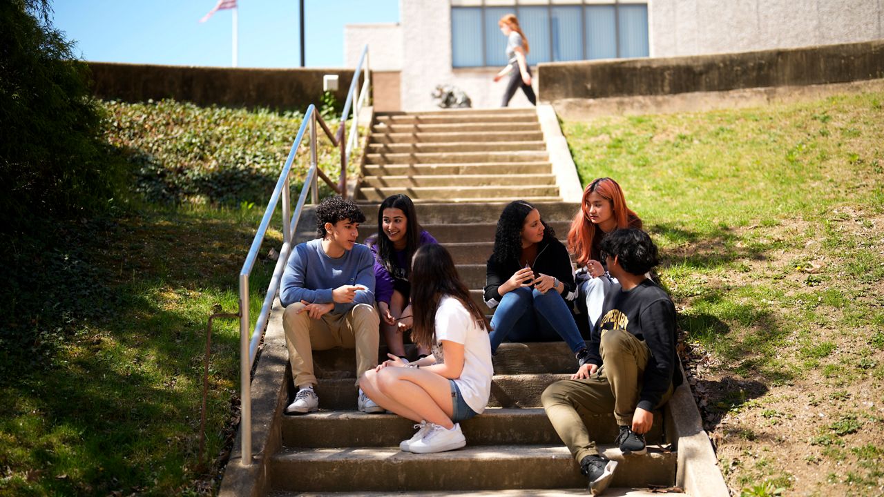 Upper Darby High School students Rayan Hansali, from left, Tanveer Kaur, Elise Olmstead, Fatima Afrani, Joey Ngo and Ata Ollah, talk in the campus courtyard, Wednesday, April 12, 2023, in Drexel Hill, Pa. For some schools, the pandemic allowed experimentation to try new schedules. Large school systems including Denver, Philadelphia and Anchorage, Alaska, have been looking into later start times. (AP Photo/Matt Slocum)