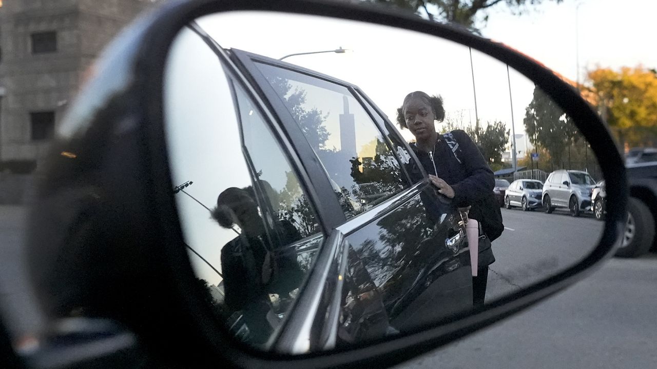 Takia Phillips, 15, arrives at her school on Friday, Oct. 18, 2024, after she was one of two children PiggyBack Network co-founder and CEO Ismael El-Amin helped drive to school as part of the Piggyback ride-share network in Chicago. (AP Photo/Charles Rex Arbogast)