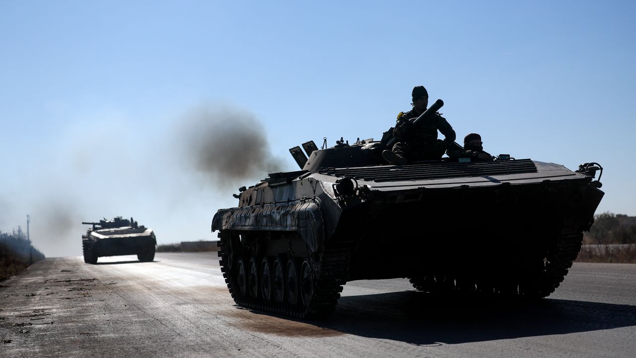 Syrian opposition fighters drive a seized seized Syrian army armoured vehicle near the town of Khan Assubul, Syria, southwest of Aleppo, Sunday, Dec. 1, 2024. Syrian opposition insurgency launched a campaign on Wednesday with a two-pronged attack on Aleppo and the countryside around Idlib.(AP Photo/Ghaith Alsayed)