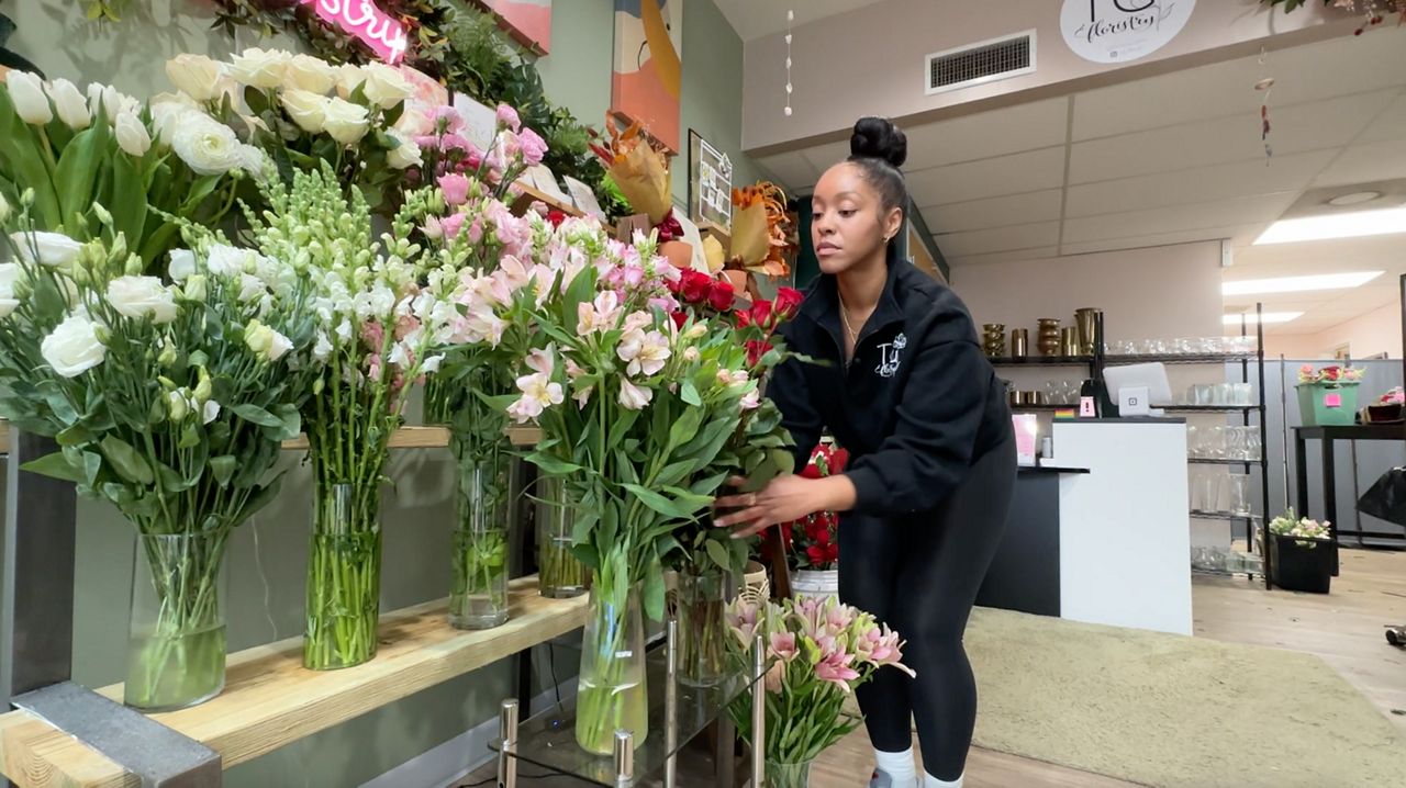 Tierra George fills a flower vase at her shop, TG Floristry, in downtown Raleigh.