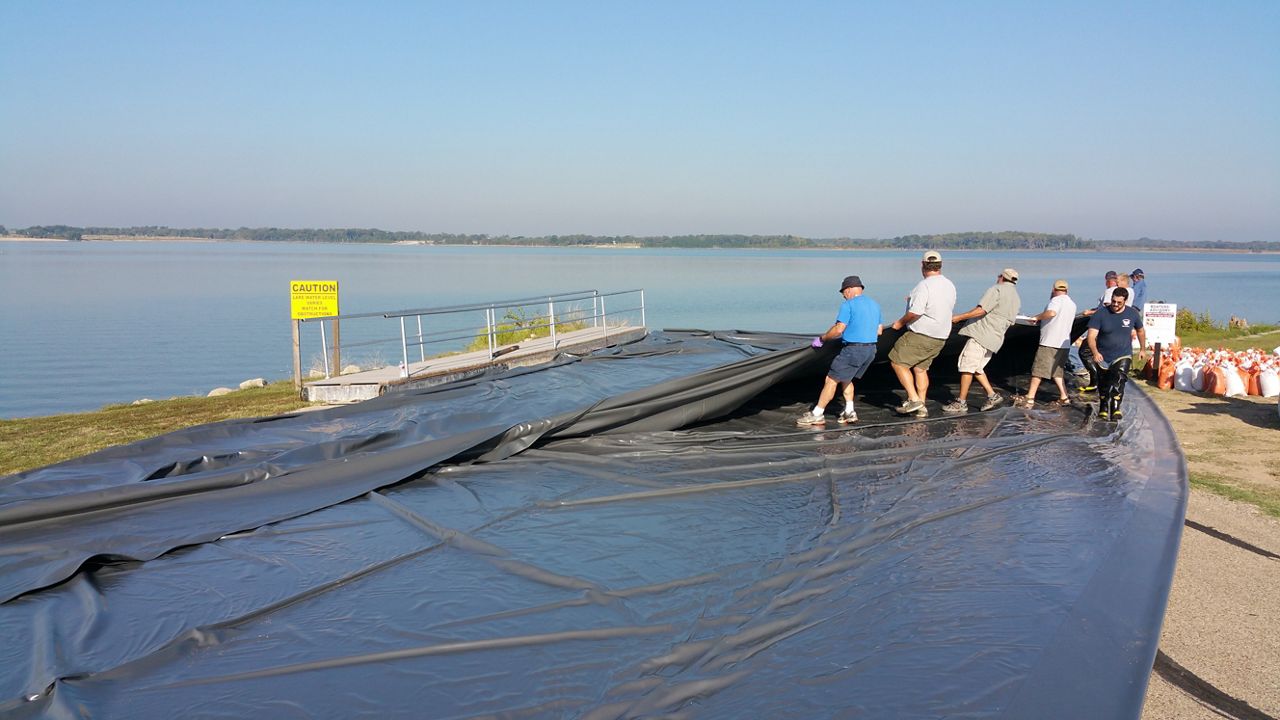 Crews placed plastic sheets over an acre of shoreline and lake bottom in an attempt to prevent the invasive zebra mussels from getting oxygen. It's the first time this eradication method has been successfully used. (Courtesy: TPWD)