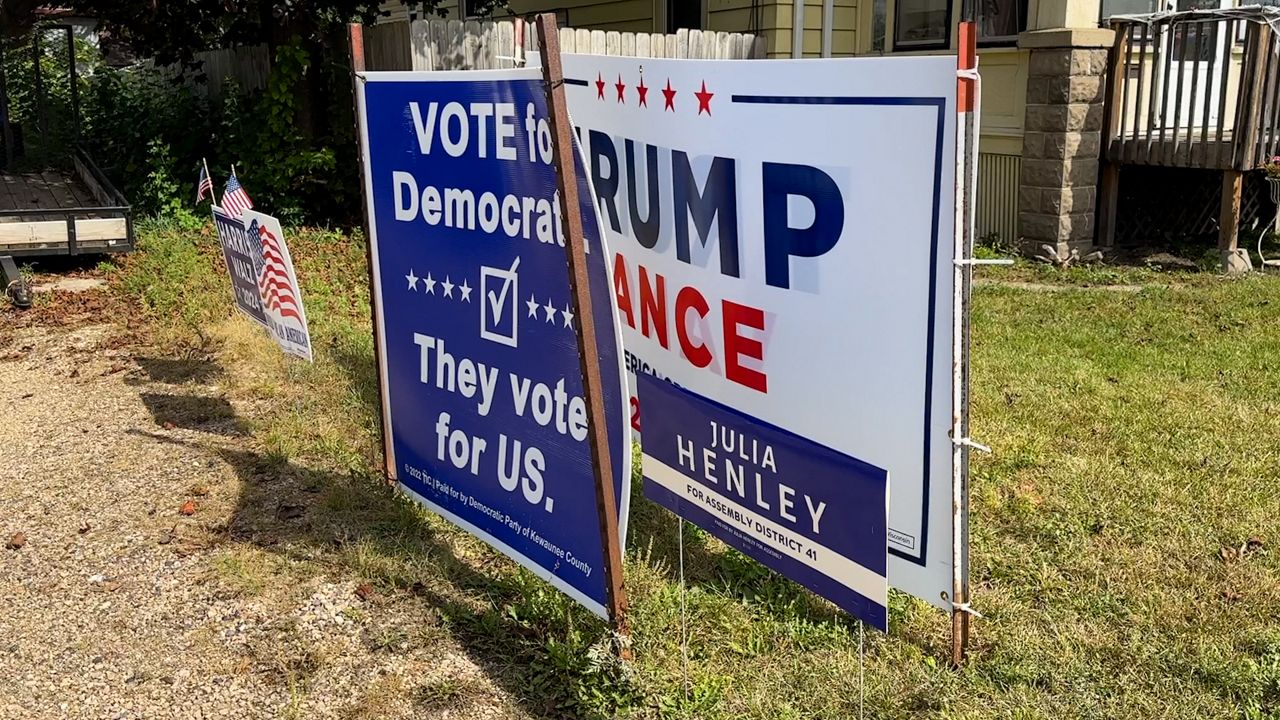 Campaign signs for Vice President Kamala Harris and former President Donald Trump next to one another in Reedsburg, Wis. (Spectrum News 1/Mandy Hague)