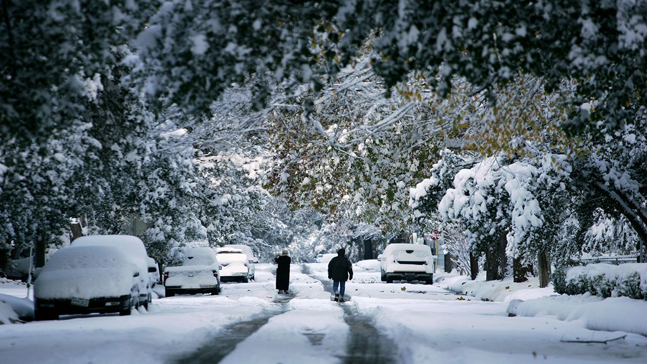 Two poeple walk throughthe snow in Victoria, Texas. (Photo by William Luther/Associated Press)