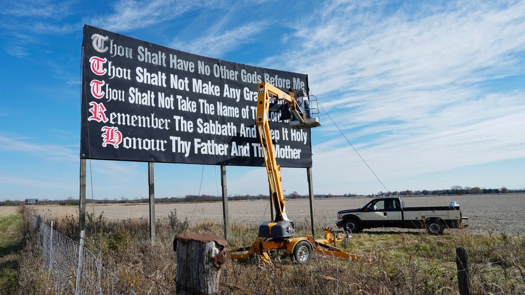 Workers repaint a Ten Commandments billboard off of Interstate 71 on Election Day near Chenoweth, Ohio, Tuesday, Nov. 7, 2023. Louisiana has become the first state to require that the Ten Commandments be displayed in every public school classroom under a bill signed into law by Republican Gov. Jeff Landry on Wednesday. (AP Photo/Carolyn Kaster, File)