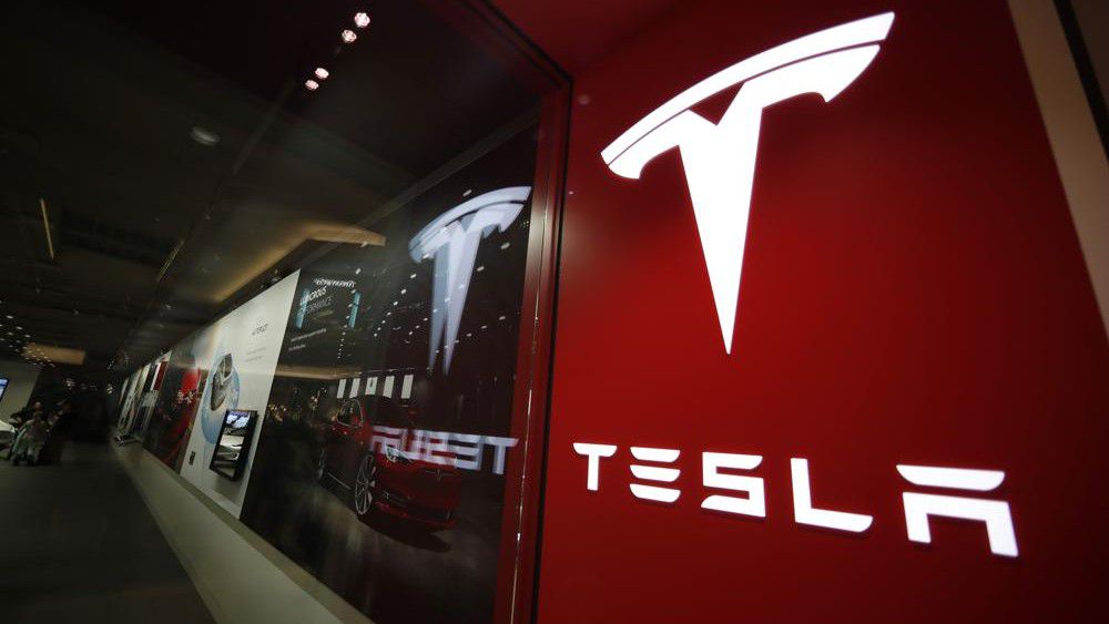 This photo shows a sign bearing the company logo outside a Tesla store Feb. 9, 2019 in Cherry Creek Mall in Denver. Tesla says it has officially moved its corporate headquarters from Silicon Valley to a large factory under construction outside of Austin, Texas. The company made the announcement late Wednesday, Dec. 1, 2021 in a filing with U.S. securities regulators. (AP Photo/David Zalubowski, File)
