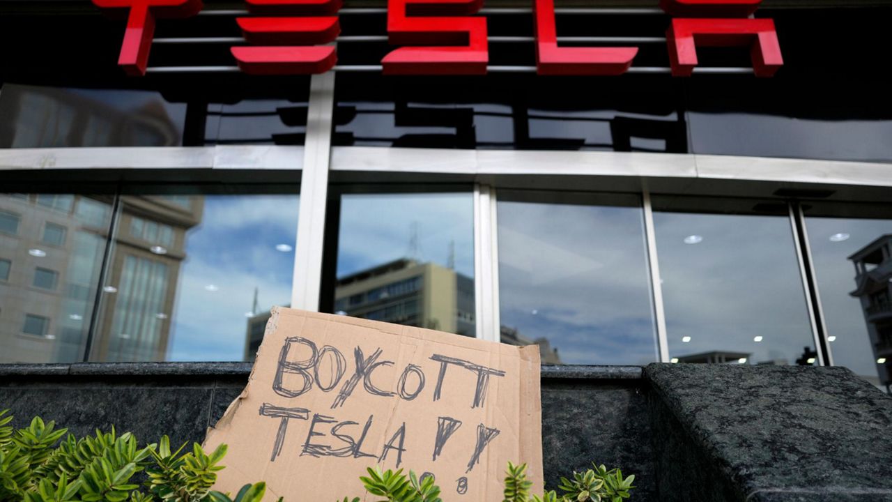 A banner is left outside a Tesla showroom during a demonstration, in Lisbon, Sunday, March 9, 2025. (AP Photo/Armando Franca)