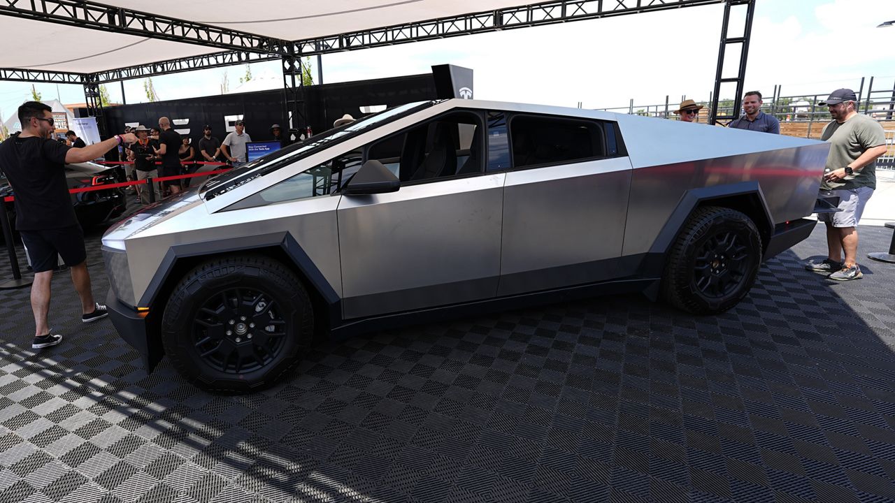 Visitors look over a 2024 Cybertruck in the Tesla display at the Electrify Expo, July 14, 2024, in north Denver. (AP Photo/David Zalubowski, File)