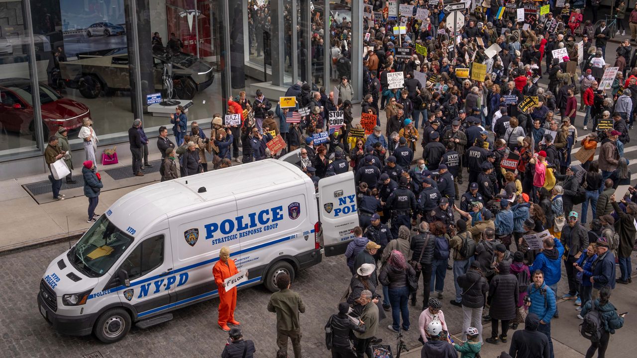 Demonstrators are arrested by NYPD officers during a protest against Elon Musk and Tesla outside of a Tesla showroom, Saturday, March 01, 2025 in New York. (AP Photo/Adam Gray)