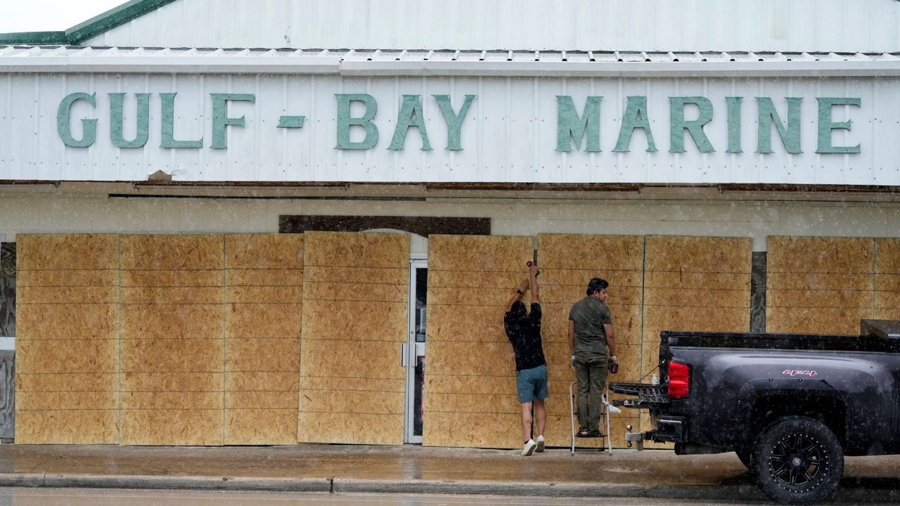 Doan Vu, left, and Luan Nguyen, right, board up windows as they prepare for Beryl's arrival, Sunday, July 7, 2024, in Palaciios, Texas. Texas officials are telling coastal residents to expect power outages and flooding as Beryl was forecast to regain hurricane strength before making landfall early Monday. (AP Photo/Eric Gay)