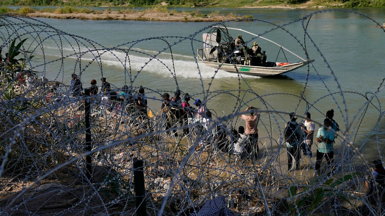 Migrants who crossed into the U.S. from Mexico are met with concertina wire along the Rio Grande, Sept. 21, 2023, in Eagle Pass, Texas.. (AP Photo/Eric Gay, File)