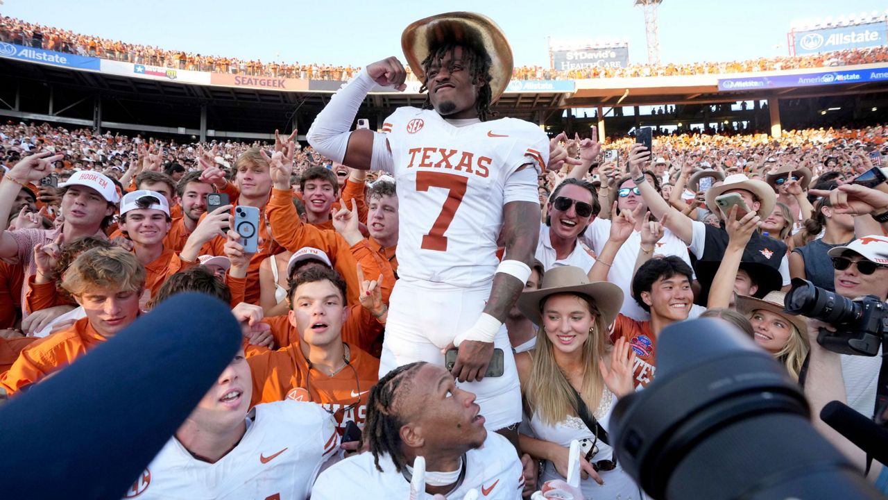 Texas defensive back Jahdae Barron (7) wears the Golden Hat Trophy as he celebrates the team's win against Oklahoma with fans after an NCAA college football game in Dallas, Saturday, Oct. 12, 2024. (AP Photo/Jeffrey McWhorter)