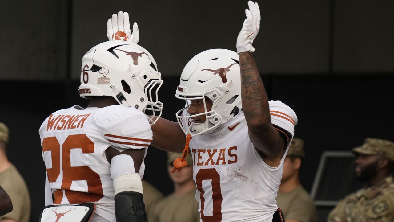 Texas wide receiver DeAndre Moore Jr. (0) celebrates a touchdown with running back Quintrevion Wisner (26) during the first half of an NCAA college football game against Vanderbilt, Saturday, Oct. 26, 2024, in Nashville, Tenn. (AP Photo/George Walker IV)