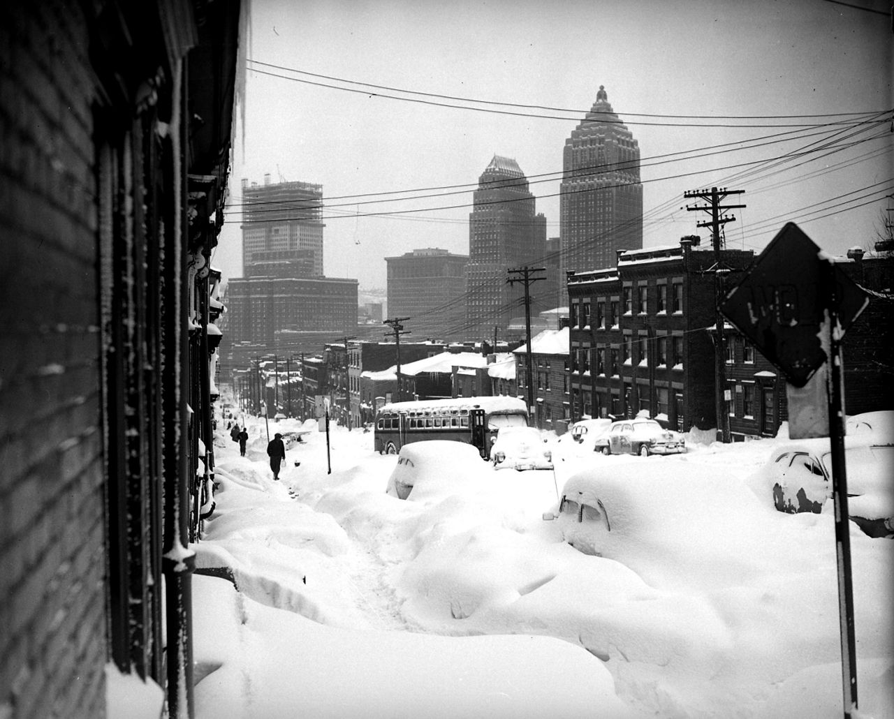 Mirando hacia el centro de Pittsburgh, Webster Avenue está enterrada bajo la nieve el 26 de noviembre de 1950, después de una nevada récord.  El rascacielos Mellon está en construcción al fondo a la izquierda.  (Foto AP/Walter Stein)