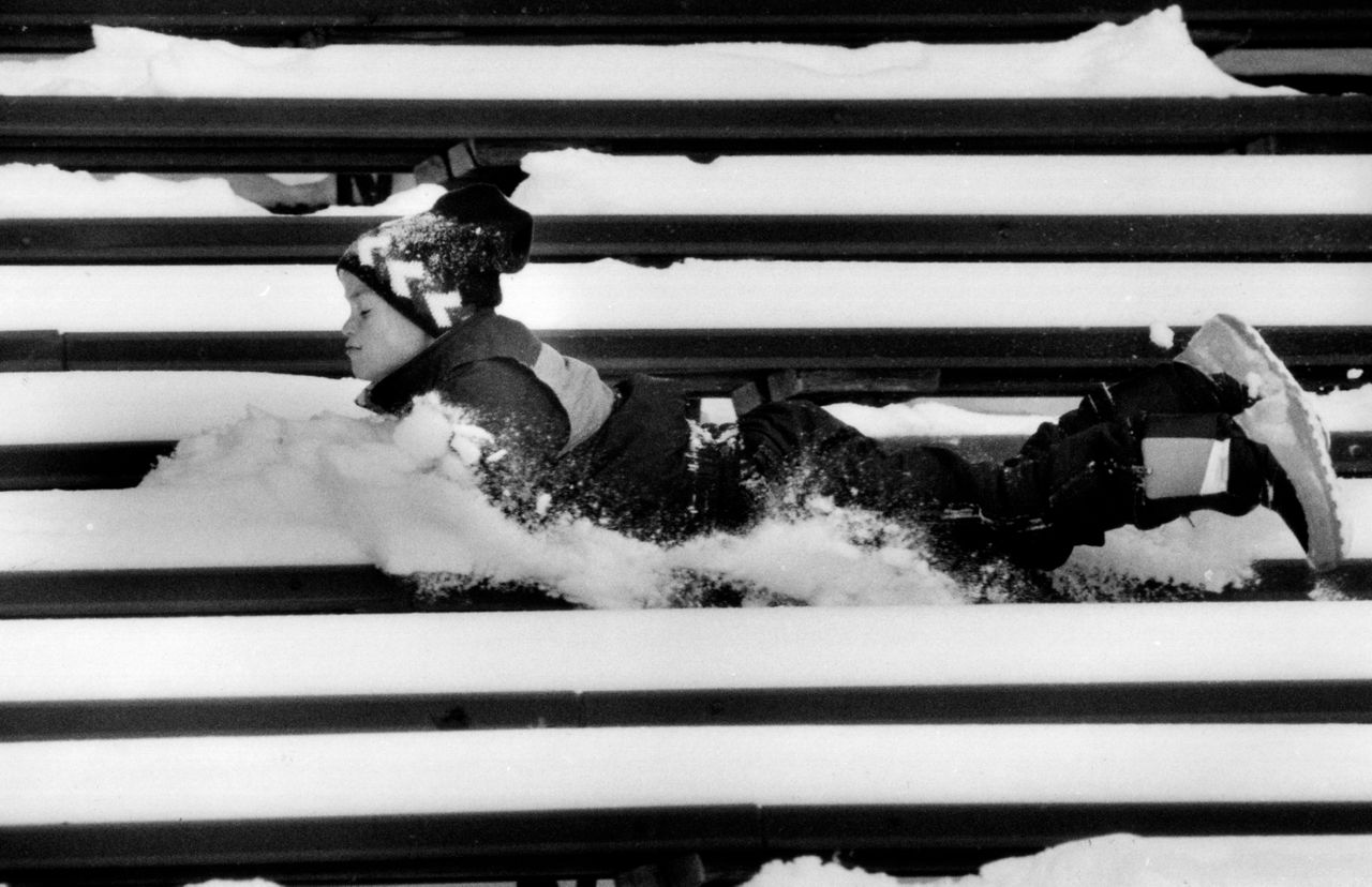 Ryan Tuman, de 9 años, de Erdenheim, Nueva York, corre boca abajo sobre las gradas cubiertas de nieve durante el partido de fútbol americano Penn-Cornell en Filadelfia, el 23 de noviembre de 1989. (Foto AP/Amy Sancetta)
