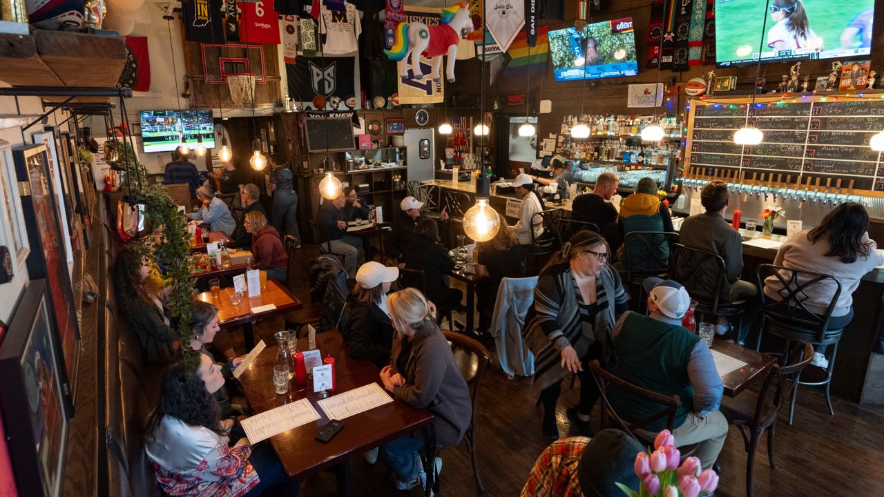 Customers eat and watch college women's lacrosse and beach volleyball matches on big-screen TVs at The Sports Bra sports bar on Wednesday, April 24, 2024, in Portland, Ore.