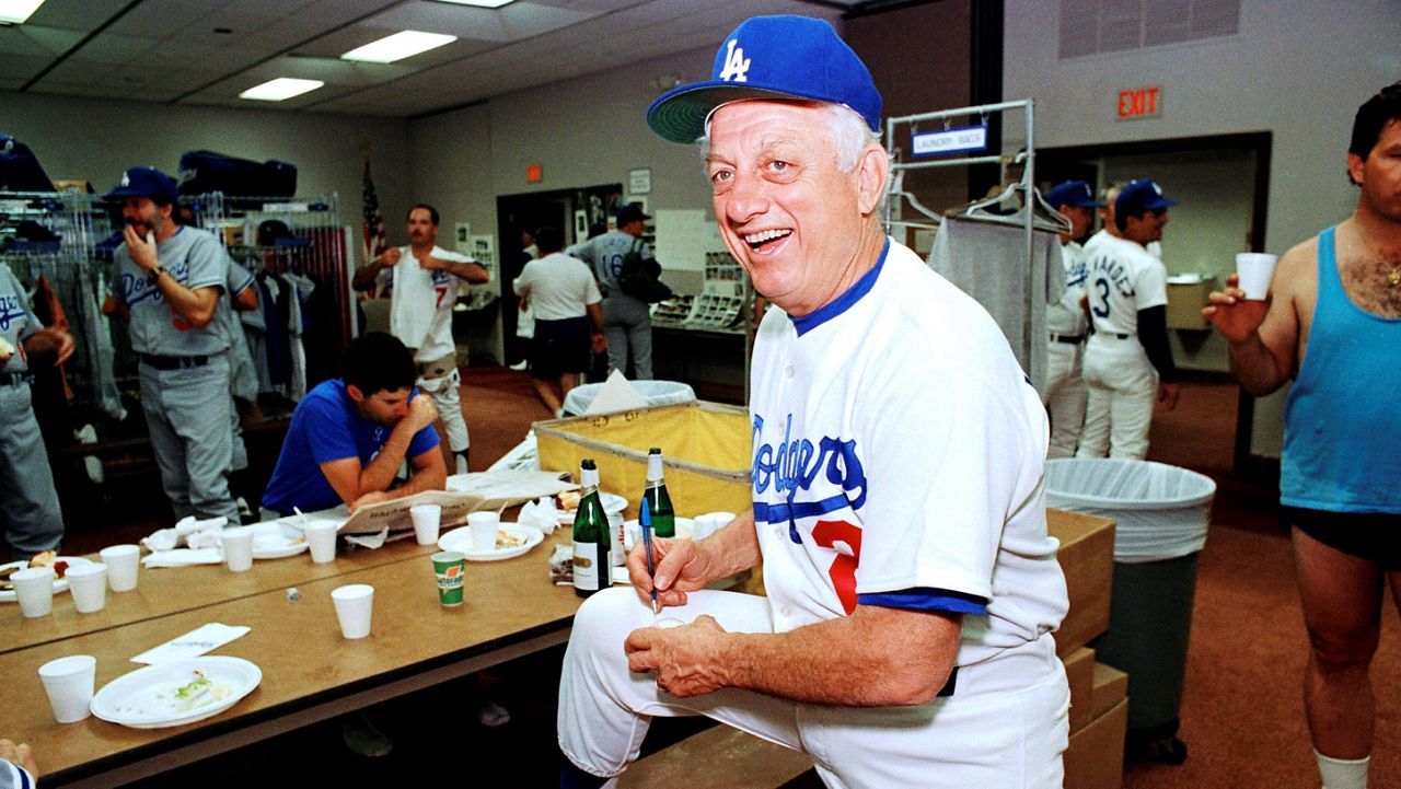 Los Angeles Dodgers manager Tommy Lasorda autographs a baseball in the Dodgertown locker-room in Vero Beach, Fla., in this Wednesday, Feb. 15, 1990, file photo. (AP Photo/Richard Drew, File)