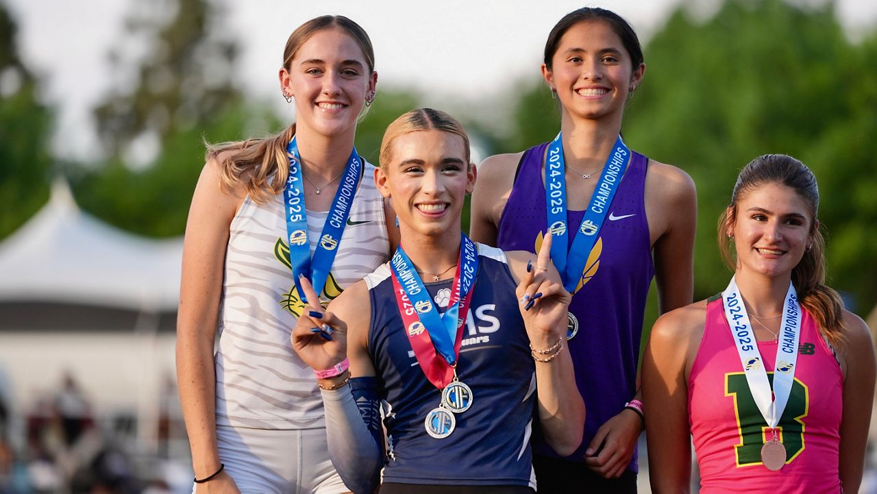 AB Hernandez, center, flashes a sign as she shares the first-place spot on the podium with Jillene Wetteland, left, and Lelani Laruelle during a medal ceremony for the high jump at the California high school track-and-field championships in Clovis, Calif., Saturday, May 31, 2025. At right is third-place finisher Julia Teven. (AP Photo/Jae C. Hong)