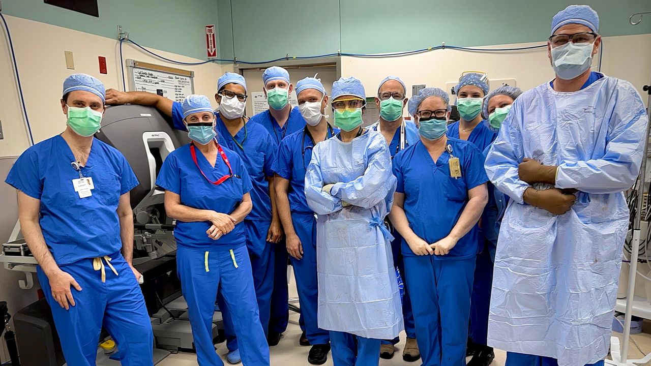 Pictured is the surgical team who performed the nation's first robotic liver transplant successfully in May. Lead transplant surgeon, Dr. Adeel Khan, has his arm draped over the robot console and the actual robot was at the patient's bedside. (Photo Courtesy of Adeel Khan)