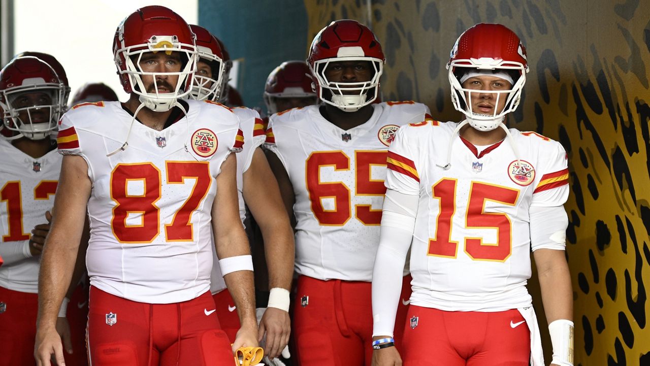 Kansas City Chiefs tight end Travis Kelce (87) and quarterback Patrick Mahomes (15) wait to lead the team onto the field before a preseason NFL football game against the Jacksonville Jaguars, Aug. 10, 2024, in Jacksonville, Fla. (AP Photo/Phelan M. Ebenhack, File)