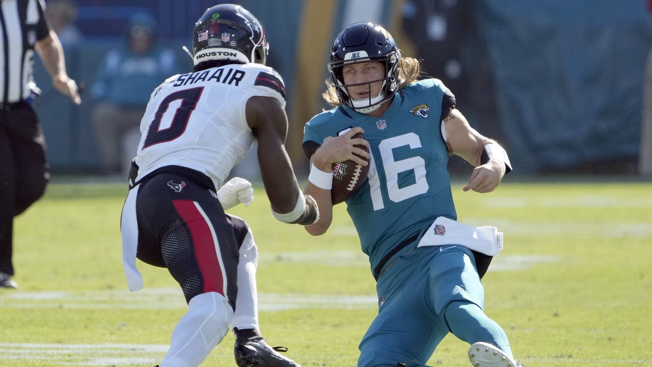 Jacksonville Jaguars quarterback Trevor Lawrence (16) slides in front of Houston Texans linebacker Azeez Al-Shaair (0) during the first half of an NFL football game Sunday, Dec. 1, 2024, in Jacksonville, Fla. Lawrence was injured on the play. (AP Photo/John Raoux)