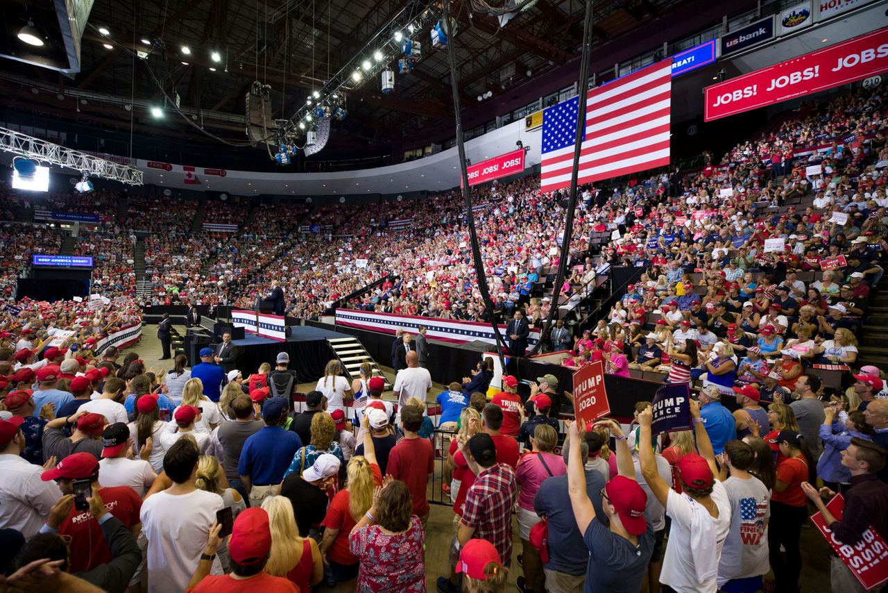 Trump denounces Dems at rally, plays down race