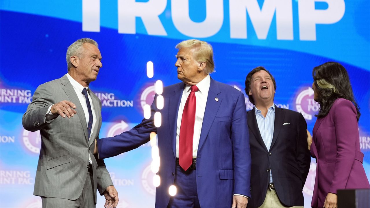 Former Democratic Rep. Tulsi Gabbard talks with Tucker Carlson as Republican presidential nominee former President Donald Trump talks with Robert F. Kennedy Jr., during a campaign rally Wednesday, Oct. 23, 2024, in Duluth, Ga. (AP Photo/Alex Brandon)