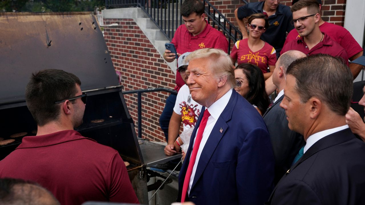 Former President Donald Trump meets with people during a stop at the Alpha Gamma Rho, agricultural fraternity, at Iowa State University before an NCAA college football game between Iowa State and Iowa, Saturday, Sept. 9, 2023, in Ames, Iowa. (AP Photo/Charlie Neibergall)