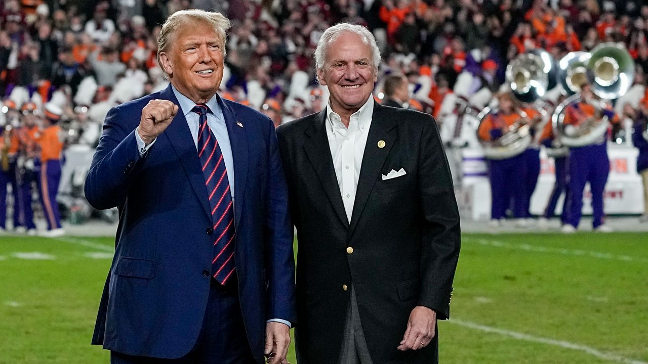 Republican presidential candidate and former President Donald Trump gestures with South Carolina Gov. Henry McMaster during halftime in an NCAA college football game between the University of South Carolina and Clemson Saturday, Nov. 25, 2023, in Columbia, S.C. (AP Photo/Chris Carlson)