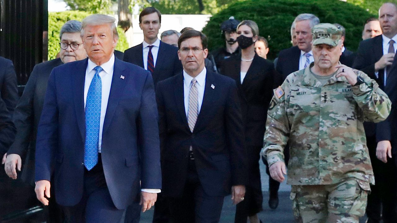 In this June 1, 2020 file photo, President Donald Trump departs the White House to visit outside St. John's Church, in Washington. Walking behind Trump from left are, Attorney General William Barr, Secretary of Defense Mark Esper and Gen. Mark Milley, chairman of the Joint Chiefs of Staff. Experts in constitutional law and the military say the Insurrection Act gives presidents tremendous power with few restraints. Recent statements by former President Donald Trump raise questions about how he might use it if he wins another term. (AP Photo/Patrick Semansky, File)
