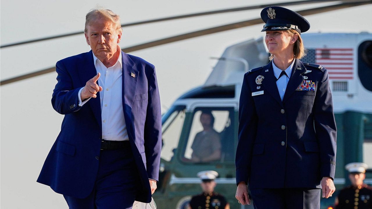 President Donald Trump, left, escorted by Air Force Col. Angela F. Ochoa, Commander, 89th Airlift Wing, walks from Marine One to board Air Force One, Tuesday, June 24, 2025, at Joint Base Andrews, Md. (AP Photo/Alex Brandon)