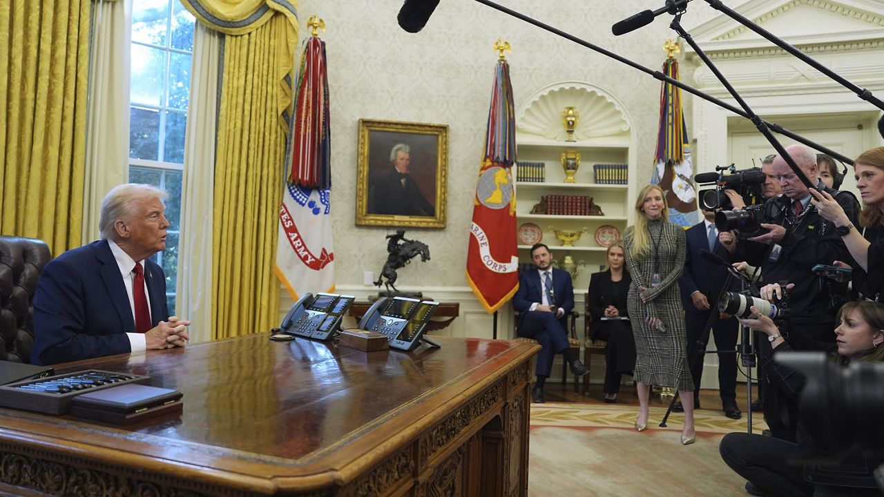 President Donald Trump talks with reporters as he signs executive orders in the Oval Office at the White House, Thursday, Jan. 30, 2025, in Washington. (AP Photo/Evan Vucci)