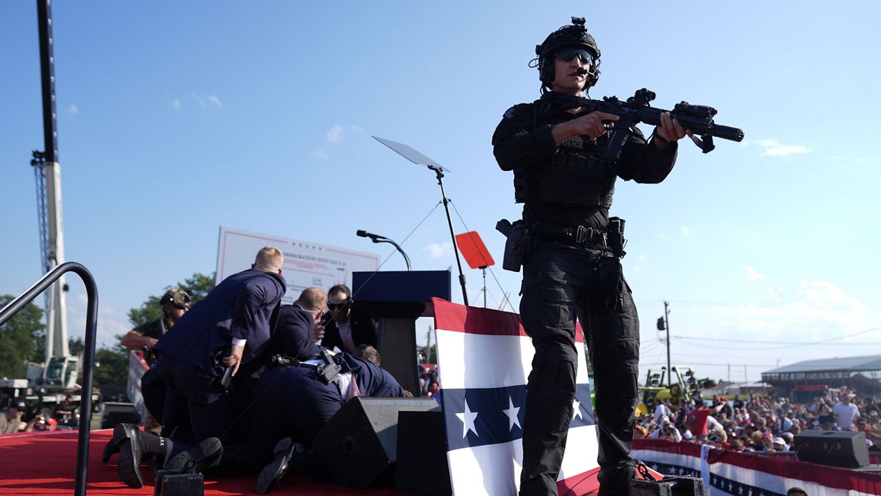 Republican presidential candidate former President Donald Trump is covered by U.S. Secret Service agents at a campaign rally, July 13, 2024, in Butler, Pa. (AP Photo/Evan Vucci)