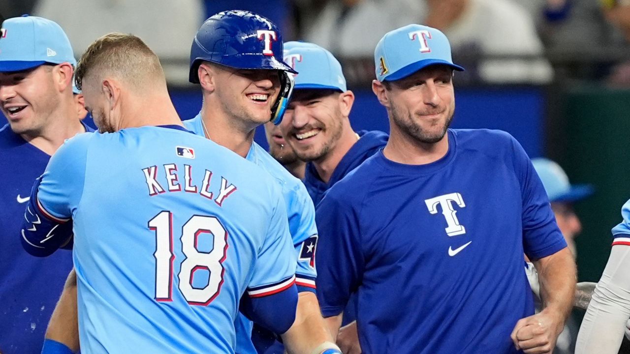 Texas Rangers' Carson Kelly (18), Josh Jung, center, and Max Scherzer, right, celebrate in the 10th inning of a baseball game after the team's 6-5 win against the Minnesota Twins, Sunday, Aug. 18, 2024, in Arlington, Texas. (AP Photo/Tony Gutierrez)