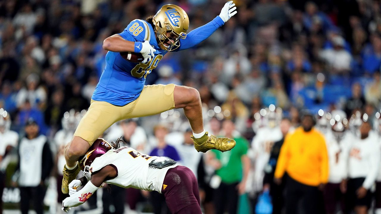 UCLA tight end Moliki Matavao, top, hurdles Arizona State defensive back Shamari Simmons during the first half of an NCAA college football game, Saturday, Nov. 11, 2023, in Pasadena, Calif. (AP Photo/Ryan Sun)