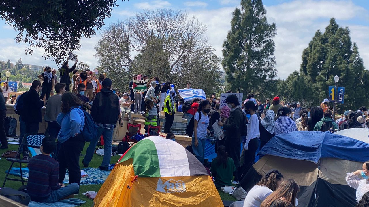 Pro-Palestinian and pro-Israel protestors stand above the Palestinian Solidarity Encampment at UCLA in Los Angeles, Thursday, April 25. (Spectrum News/David Mendez)