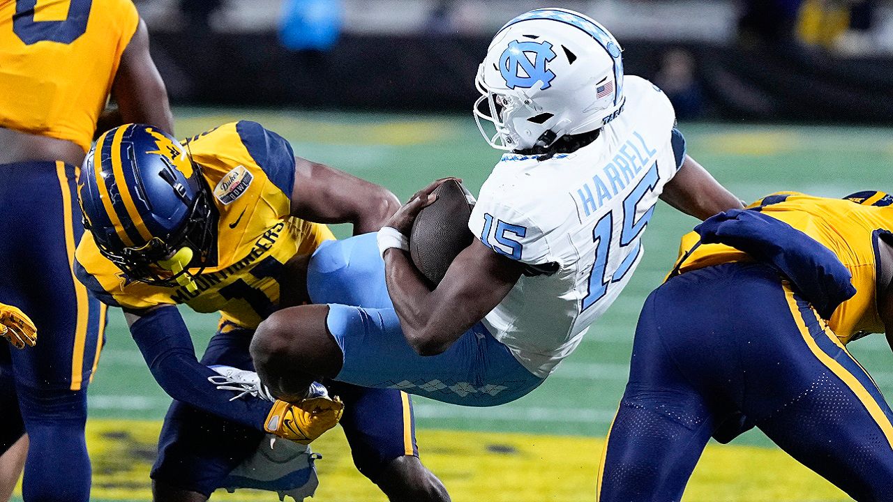 North Carolina quarterback Conner Harrell is tackled by West Virginia cornerback Beanie Bishop Jr. during the first half of an NCAA college football game at the Duke's Mayo Bowl Wednesday, Dec. 27, 2023, in Charlotte, N.C. (AP Photo/Chris Carlson)