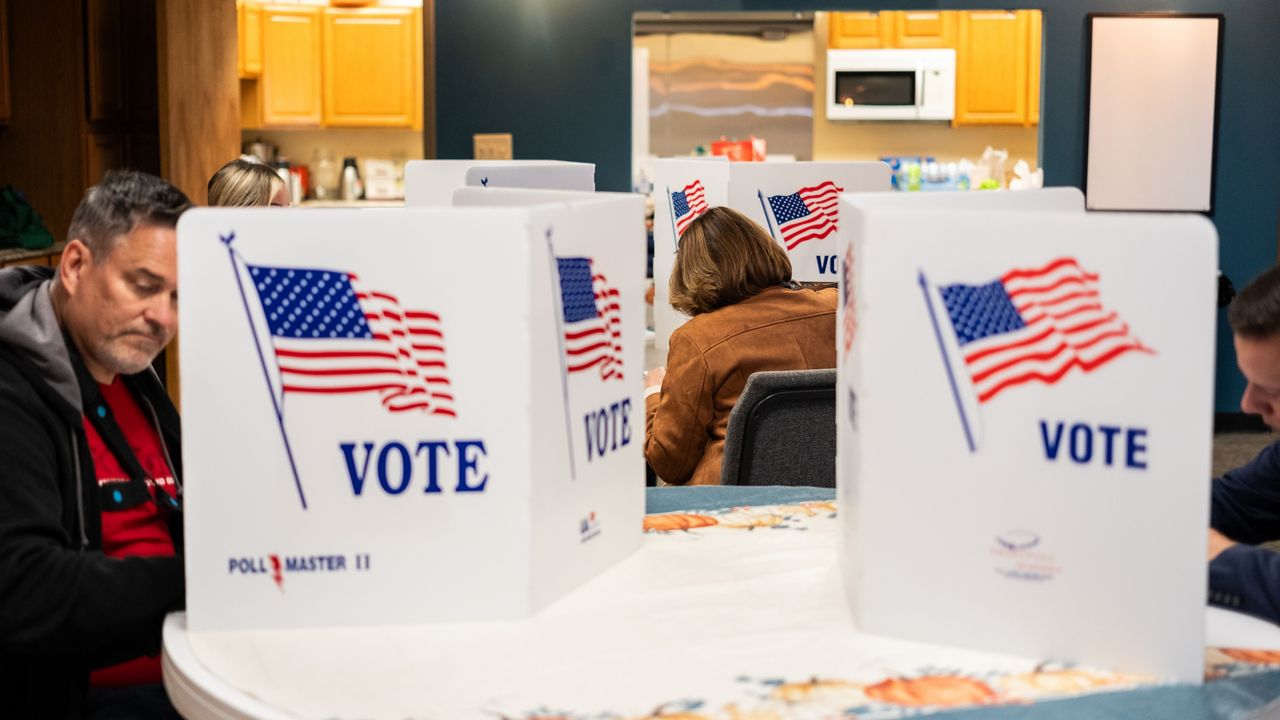 A polling place with people voting. 