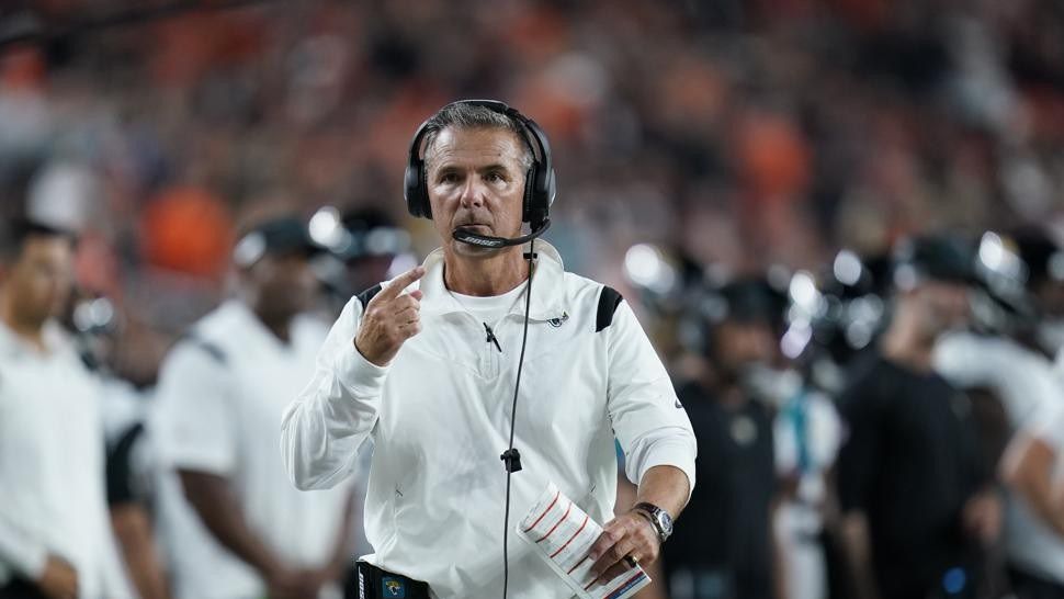 Jacksonville Jaguars head coach Urban Meyer walks with an official during the first half of an NFL football game against the Cincinnati Bengals, Thursday, Sept. 30, 2021, in Cincinnati. (AP Photo/Michael Conroy)