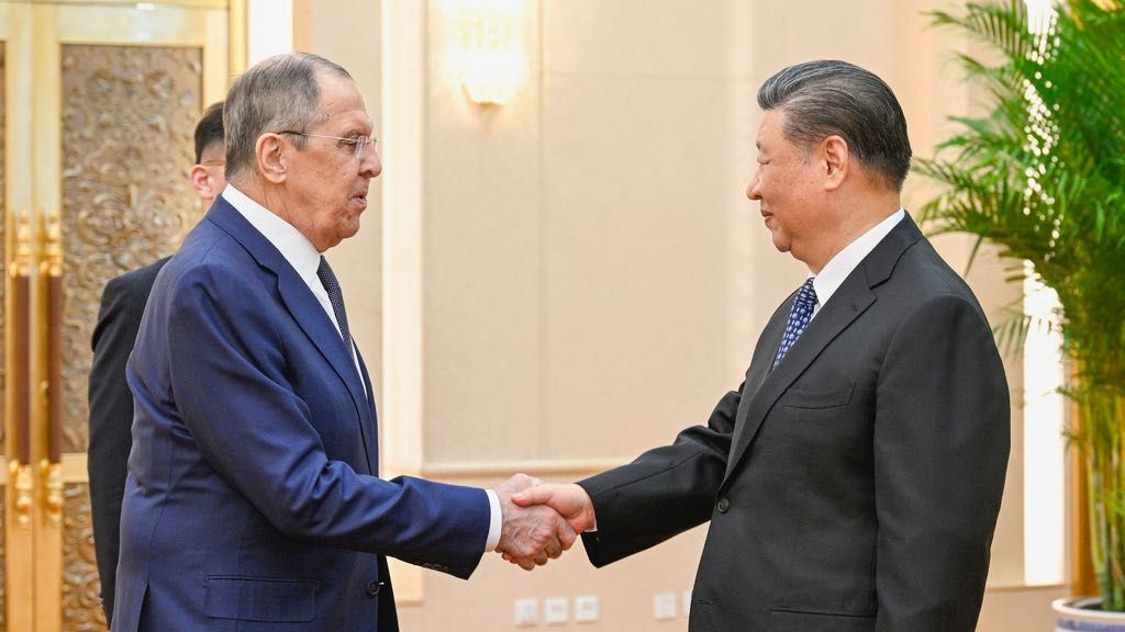 Russian Foreign Minister Sergey Lavrov, left, and Chinese President Xi Jinping meet at the Great Hall of the People in Beijing on April 9, 2024. (Li Xueren/Xinhua via AP)