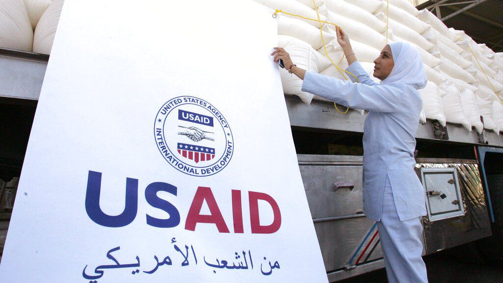Una trabajadora jordana coloca un cartel en un camión cargado con ayuda humanitaria donada por la USAID. Archivo